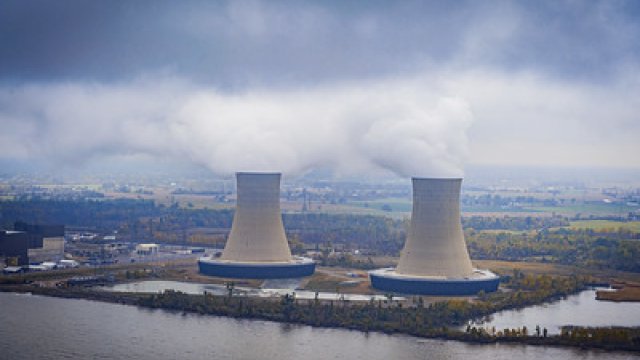 Two smoke stacks near a water body