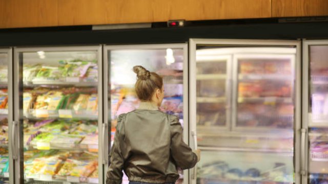Women choosing frozen food from supermarket