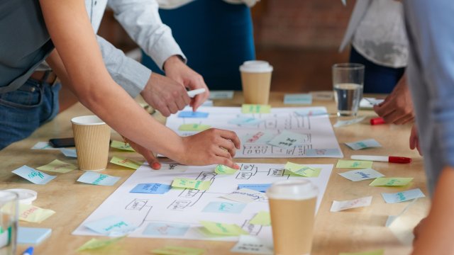 staff around table with work materials being reviewed