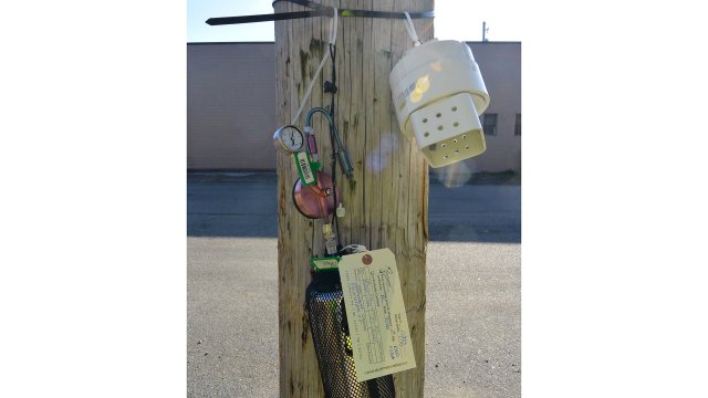 Air sampling devices are placed on an electrical pole next to Sulphur Run during culvert cleaning