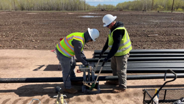  The crew is fusing a pipeline for the irrigation system that is set up to water upland planted areas around the site. 