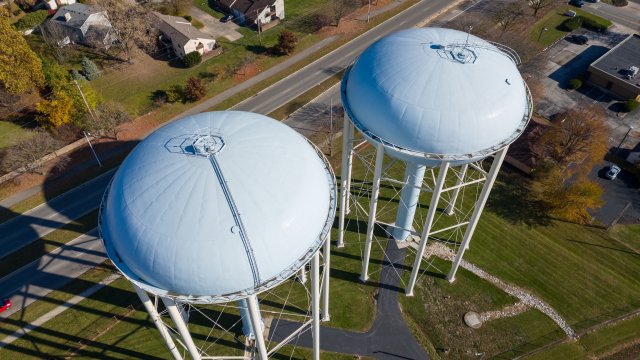 Twin water towers stand over Upper Arlington, OH, with a suburban backdrop.
