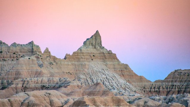 Pink sky behind rock formations at Badlands National Park. Adobe Stock Image.