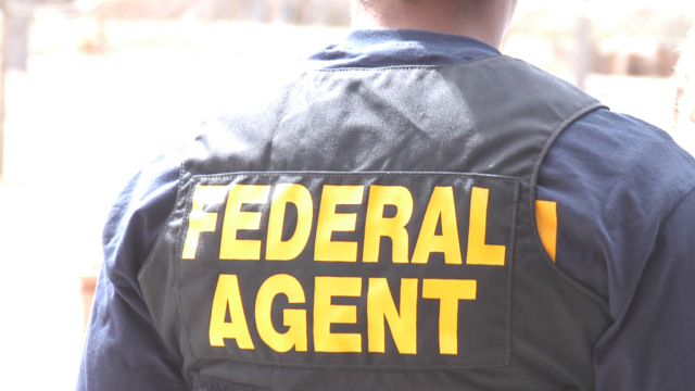back of federal agent with "special agent" on tactical vest