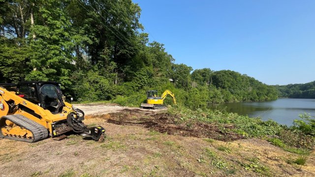 Construction machines being operated on sediment removal on the west side of the Front Street bridge.