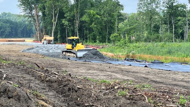 A bulldozer moving rocky material to create a temporary road.