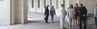 A team of diverse individuals collaborate outside before walking into a historic building
