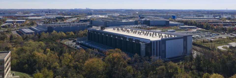 A data center surrounded by trees on a sunny day.