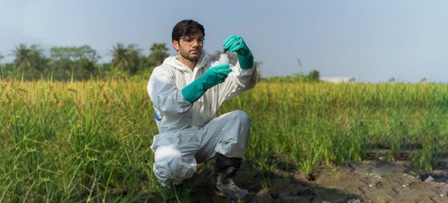 EPA scientist tests soil quality in a large field.