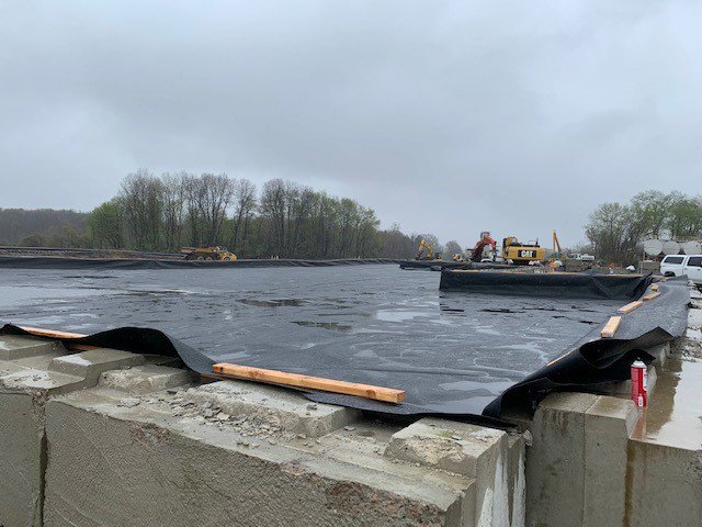 Soil waste pile lined with thick pastic and concreete barriers