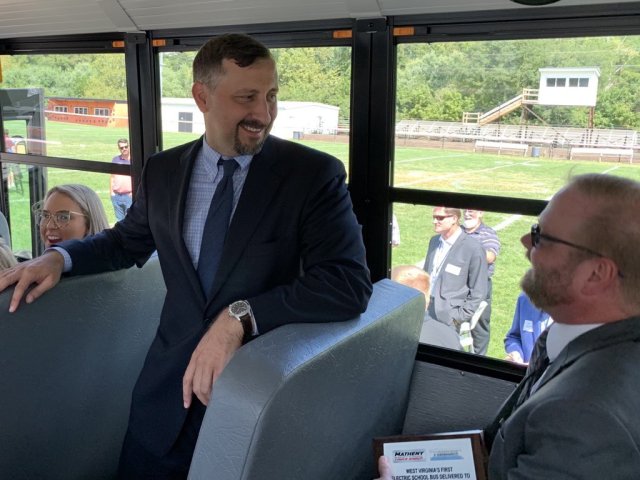 People are seen smiling inside of a bus.