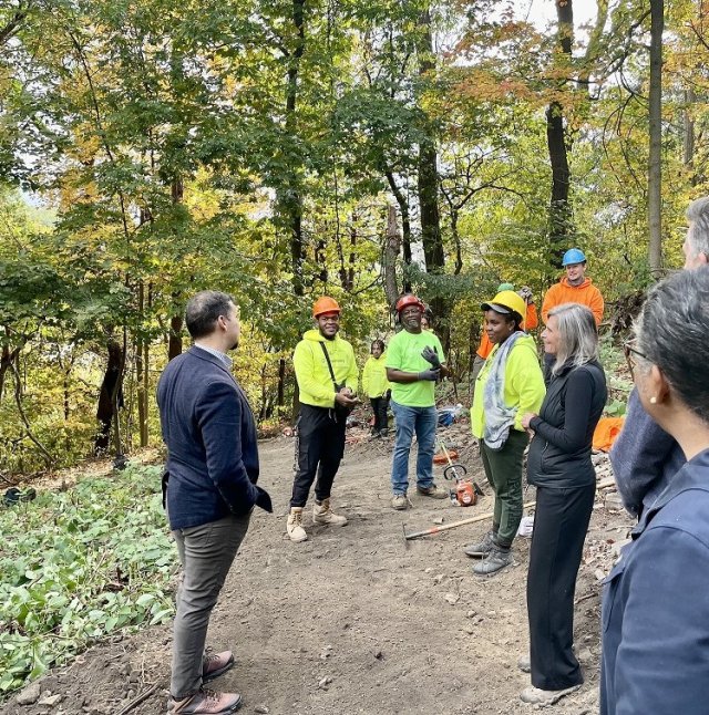 People are seen in the woods talking and smiling