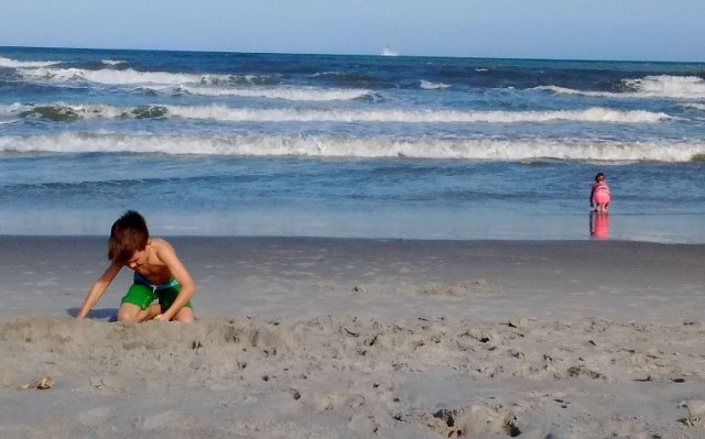 child plays at the beach