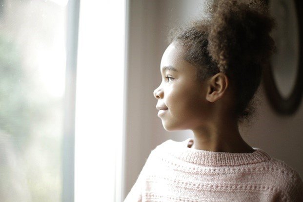 Little girl looks out window