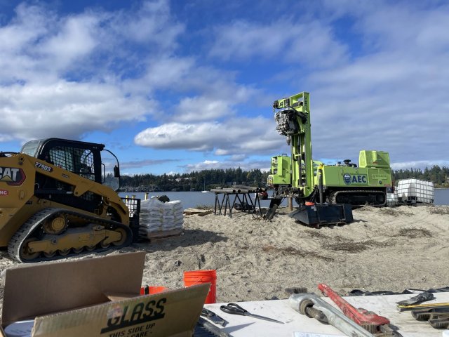 Heavy equipment conducting environmental sampling on beach area.