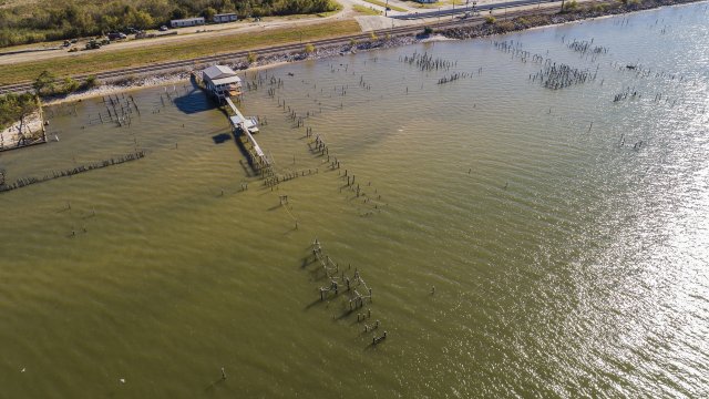 Aerial view of a pier on Lake Pontchartrain and the beach behind it,