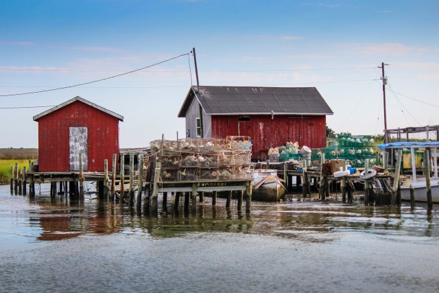 Buildings with fishing gear on stilts surrounded by tidal waters.