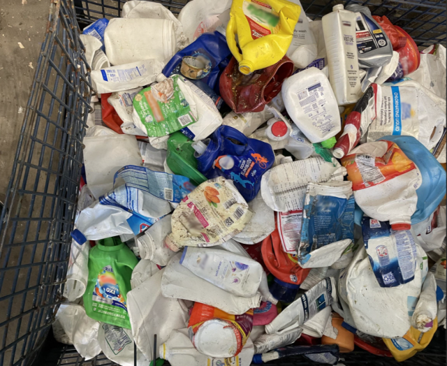 numerous plastic bottles crushed and being held in a hopper at a recycling facility