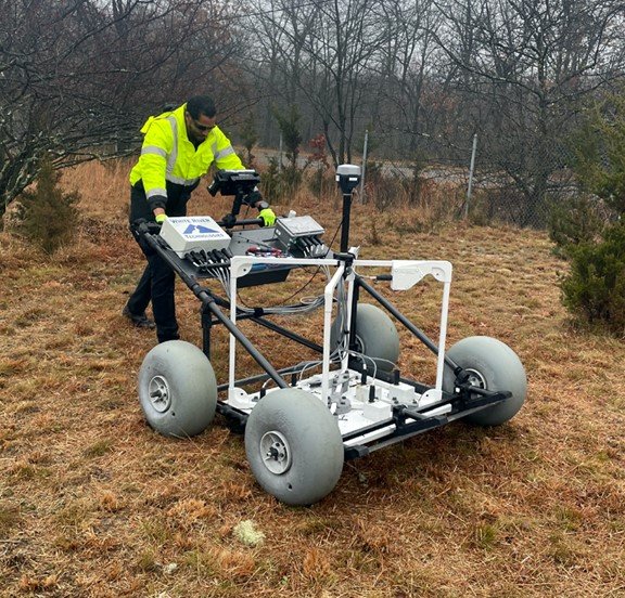 A large metal detector rolling along the ground, being tested at Edison's lead service line identification test bed.