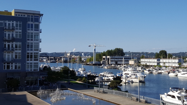 Buildings, boats and sidewalks at a waterfront.