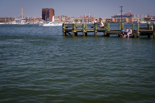 Image of people sitting on a dock in water