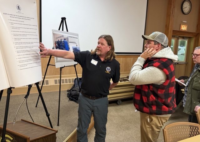 EPA staff member talks to resident about chart on easel