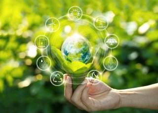 Hand holding Earth with green background