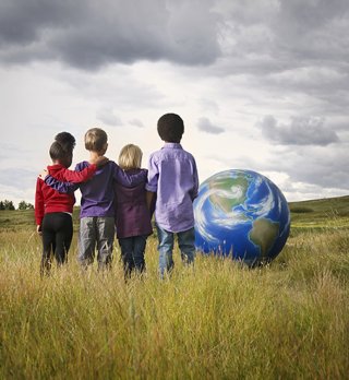 Children in a field with the Earth