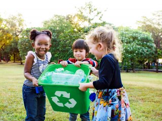 Kids with recycling bin smiling