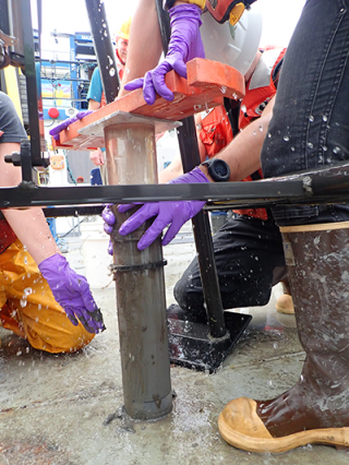 Scientist using box corer to sample Lake Superior