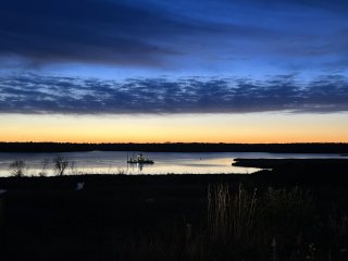 Image of the sun setting on a lake.