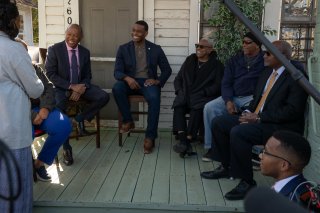 Administrator Regan sitting on a porch with community members