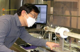 EPA researcher Yong Ho Kim conducts studies on air pollutants emitted from open burn pits and wildfires using the combustion system to generate smoke from various vegetation and synthetic materials.
