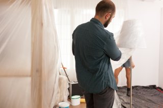 couple putting plastic sheeting down before renovation