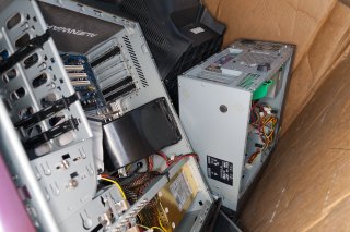 Overhead view of electronic waste in cardboard box. 