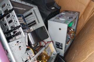 Overhead view of electronic waste in cardboard box.