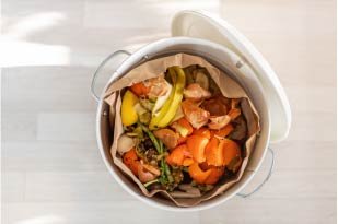 Overhead photo of compost in a white bucket. 