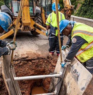 Workers installing sewer pipes