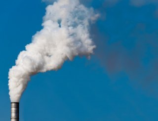 Top of a smokestack spewing smoke into the air