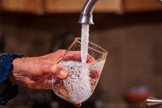 glass of water being filled from the tap
