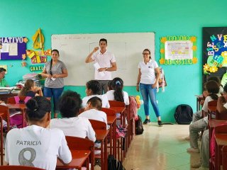 Rhina and two other teachers in front of a classroom in Ecuador