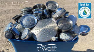 TRWD bucket filled with old showerheads for their Shower Better showerhead exchange