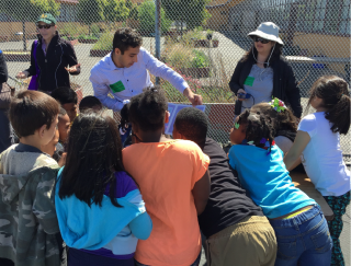 diverse group of children and adults volunteering on a science project outside