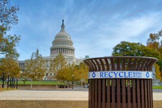 This is a picture of a recycling bin in the foreground and the Capitol building in the background.
