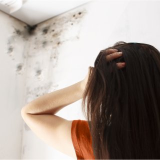 woman looking up at mold on celiing