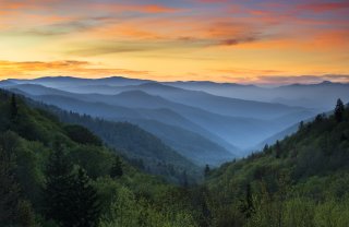 Landscape view of forested mountains during sunrise.