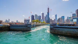 A view of Chicago Harbor Lock controlling the flow of water with Chicago's skyscrapers in the background.