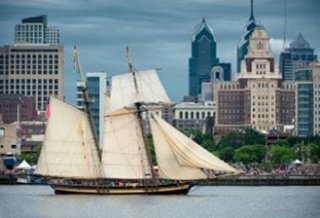 A tall ship on the Delaware River against the backdrop of Penn's Landing, Philadelphia, PA.