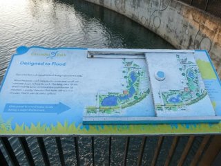 A picture of stormwater management signage in front of a body of water.