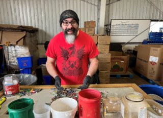 man sorting batteries into buckets